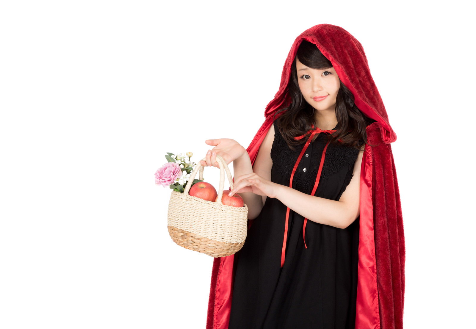 赤いフードを被った女性が白いバケットに入った赤い林檎を持っている［モデル：茜さや］