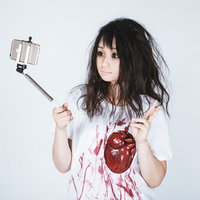セルフィ棒で自撮りするゾンビ女子のハロウィン仮装の写真