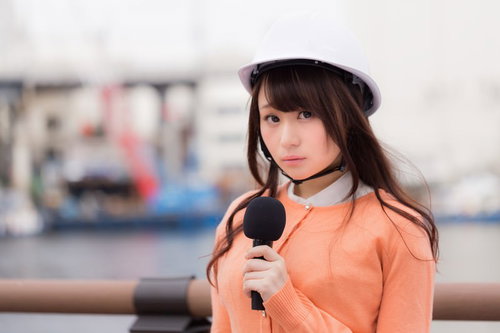 被災地からのニュース中継で安全ヘルメットを着用するアナウンサー