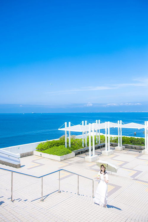 東京湾の晴れた青空と海ほたるの展望デッキで白いワンピースの女性