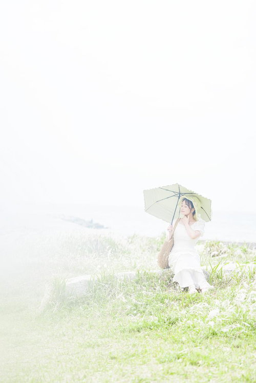 潮風に誘われて、日傘を持つ彼女の静かなひととき