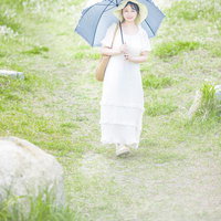 日傘をさして海岸を散歩する女子 岩井海岸での夏のポートレートの写真