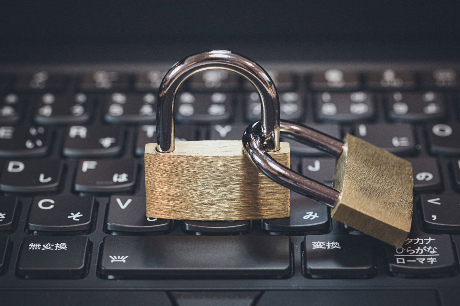 黒いキーボードの上に置かれた2つの金色の南京錠