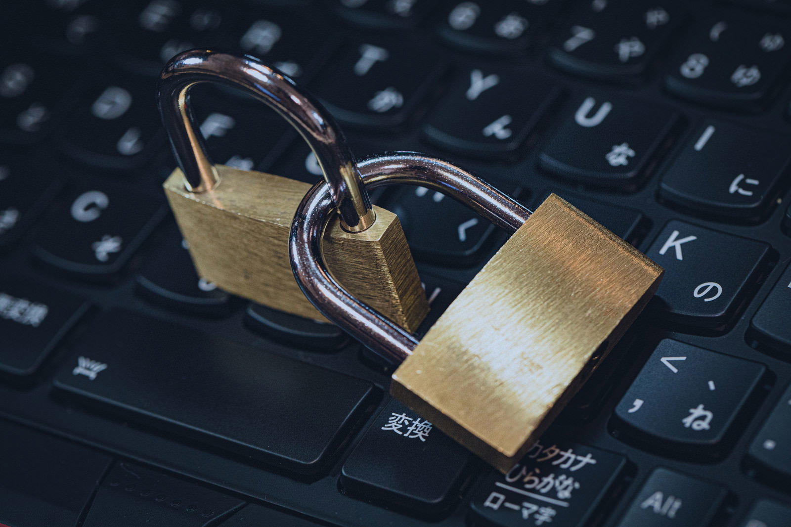 黒いキーボードの上に置かれた2つの金色の南京錠