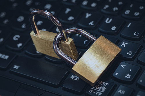 黒いキーボードの上に置かれた金色の南京錠で表現するセキュリティ対策