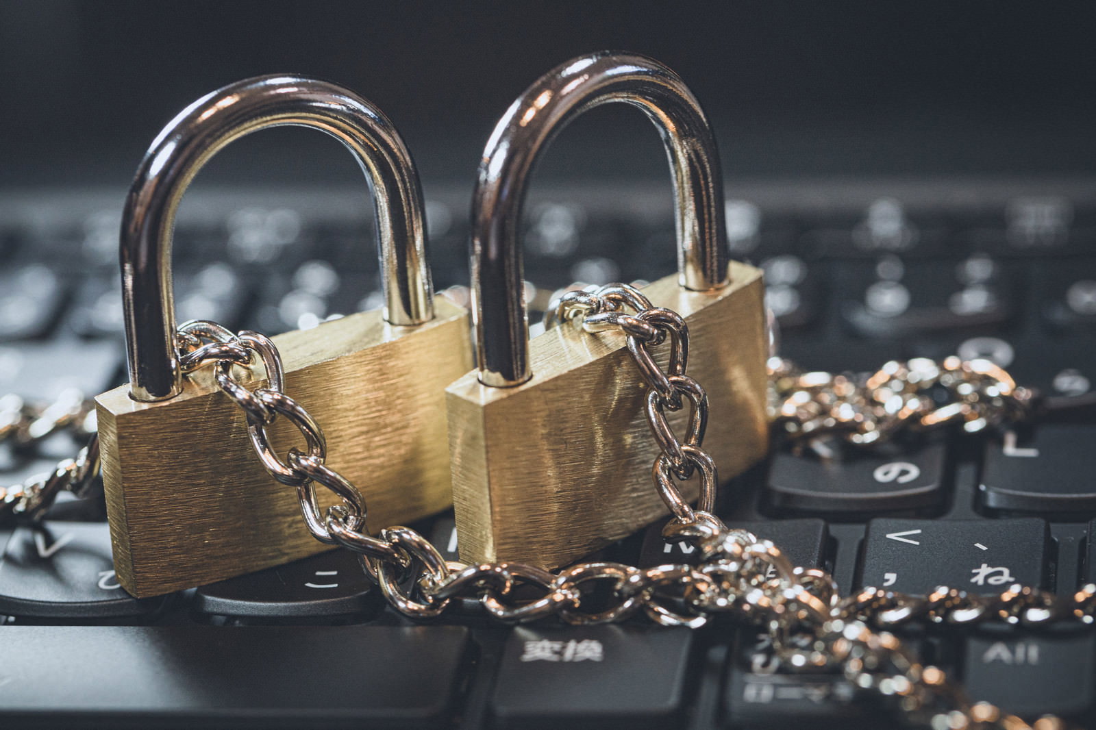 キーボードの上に置かれたチェーンで繋がれた2つの金色の南京錠