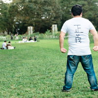 正義を極めし者・公園で腰に手を当てる男性の後ろ姿の写真