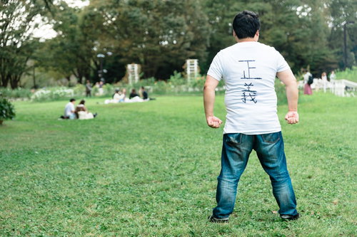 正義を極めし者・公園で腰に手を当てる男性の後ろ姿