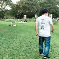 公園で見回りをする正義マンの後ろ姿の写真