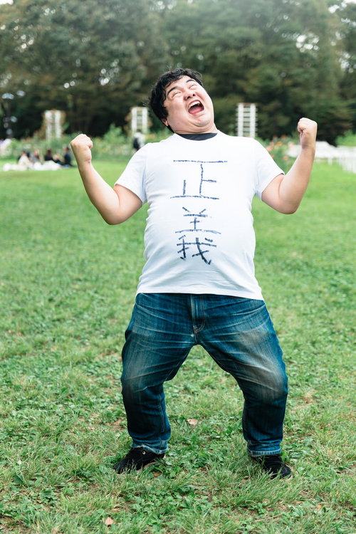 芝生の上で勝利のガッツポーズを決める正義マン