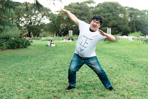 正義マン参上！公園で決めポーズをとる男性