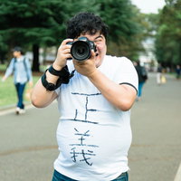 公園でファインダーを覗く正義のカメラマンの写真