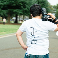 ウンチクが多そうなカメラマンさんが一眼レフを構える後ろ姿の写真