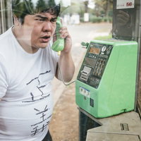 電話越しから匿名の正義執行を行う男性が公衆電話で通話するの写真