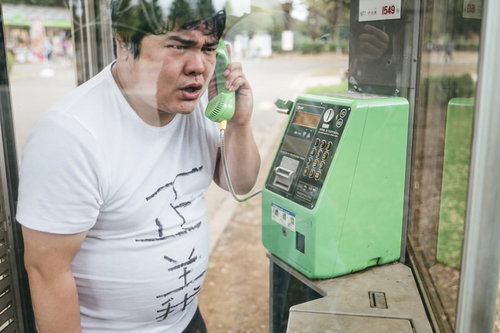 電話越しから匿名の正義執行を行う男性が公衆電話で通話する