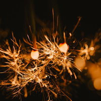 線香花火とパチパチはじける火花の夜空の写真