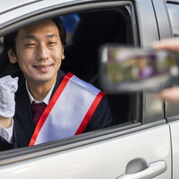 煽り運転の相手にも笑顔で対応する候補者の演説の写真