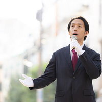 住宅街を中心に街頭演説する政治家風の男性の写真