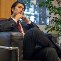 苦戦して考え込む若手の政治家、ソファーで思案する男性の写真