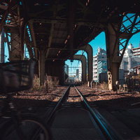 常磐線の線路と踏切が交差する高架下の町並みの写真