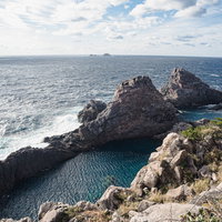 神津島の千両池と断崖絶壁 透き通った海水と荒々しい岩肌の写真
