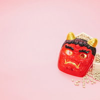 赤い鬼の面と節分の豆が並ぶセットの写真