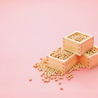 節分の豆撒き用の木製升に溢れる炒った大豆の写真