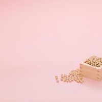 溢れ出る豆まき用の大豆と木製の枡の写真