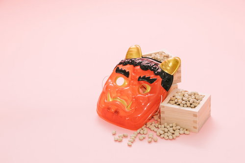 赤い鬼のお面と節分の豆を盛った升、鬼外福内の豆まき行事