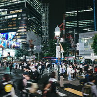 夜間に青信号で一斉に歩き出す渋谷スクランブル交差点の人混みの写真