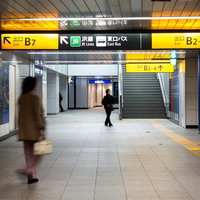 渋谷駅地下通路の案内板と通行人の写真