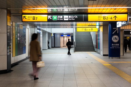 渋谷駅地下通路の案内板と通行人