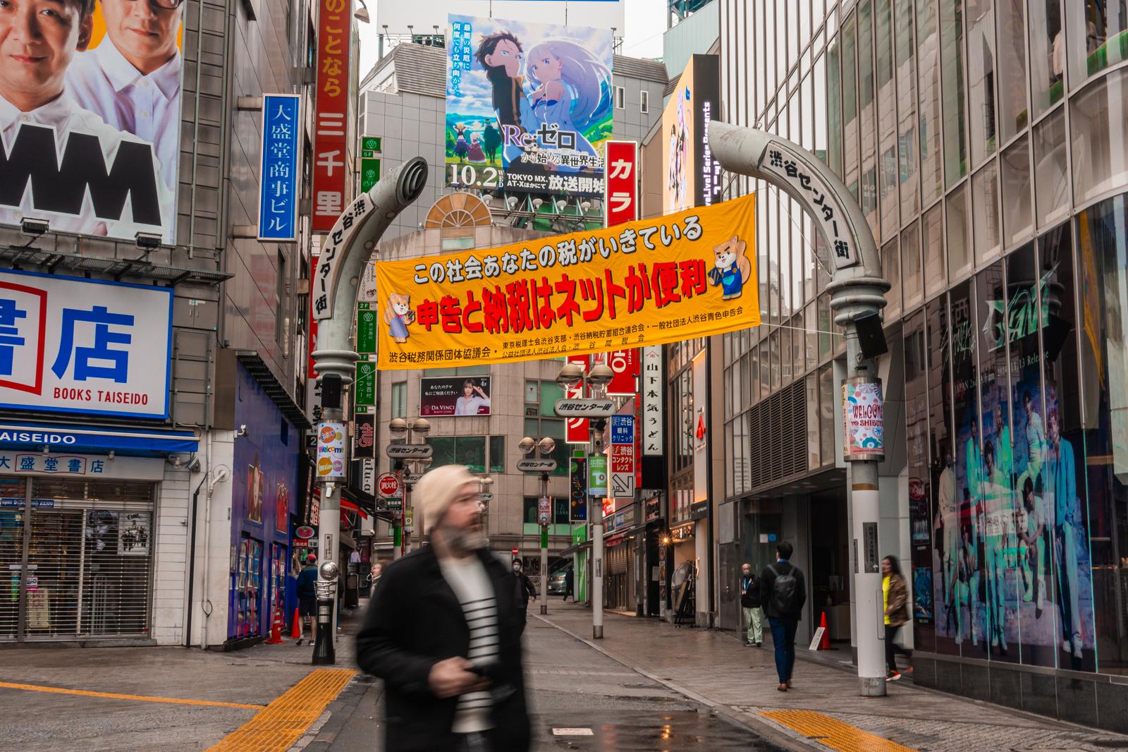 渋谷センター街の看板と歩行者。カラフルな広告が並ぶ商店街。