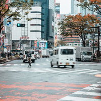 秋の渋谷スクランブル交差点を行き交う車両と歩行者の写真