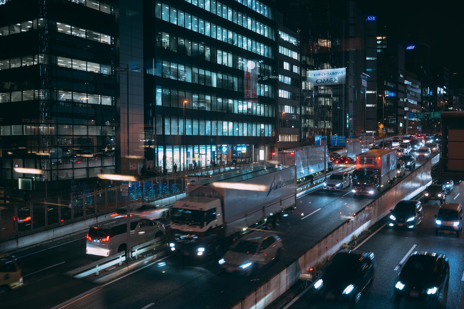 夜間のオフィス街を走る首都高速道路と高層ビル群