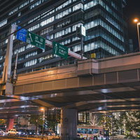 夜間の首都高速3号渋谷線と高層ビル群の都市夜景の写真