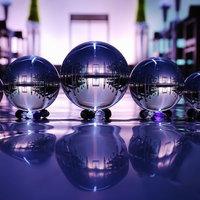 静寂な空間に一列に並ぶ透明な水晶玉とガラス玉の光と影の写真