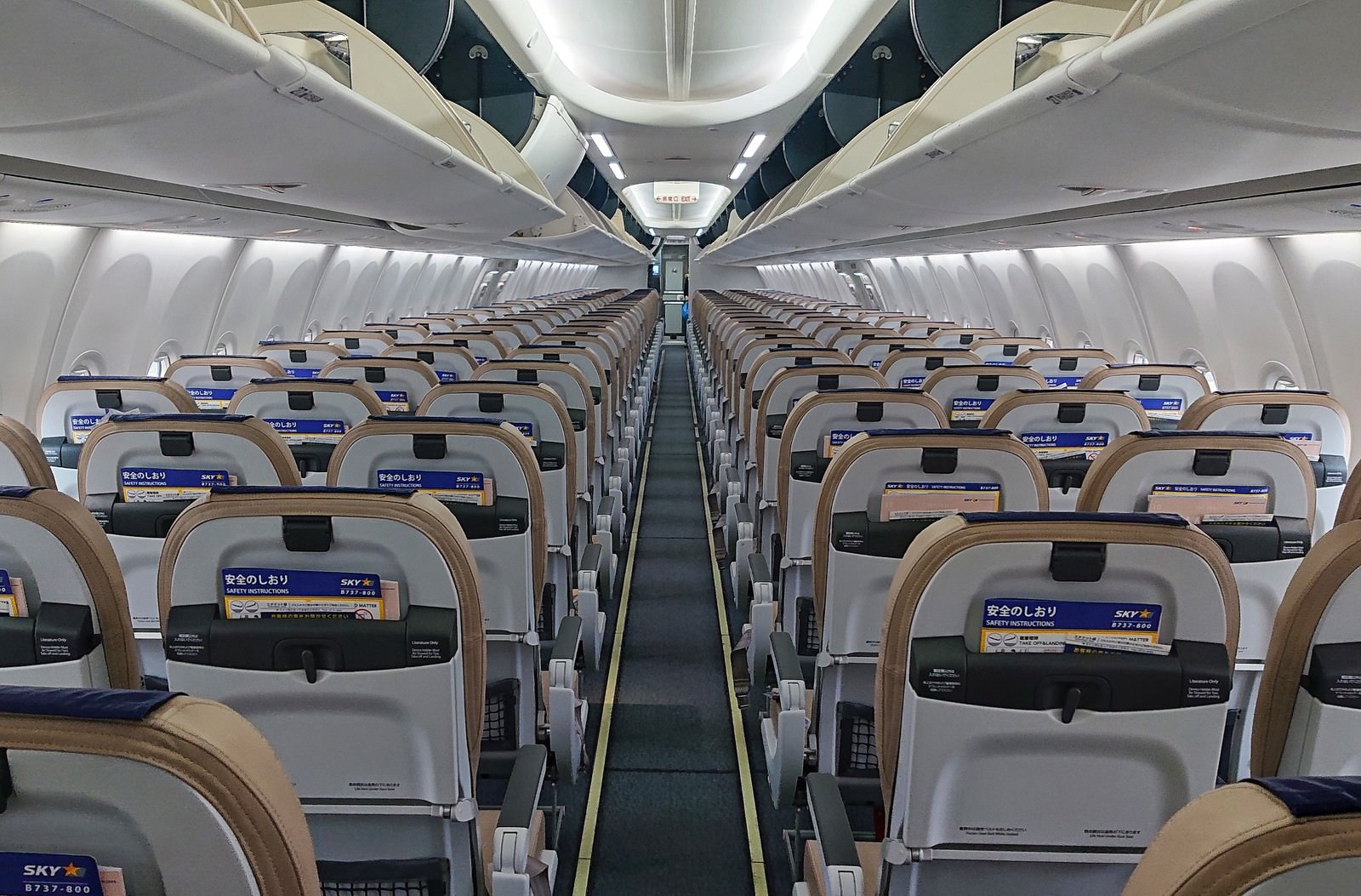 搭乗前の飛行機のエコノミークラス機内で通路を挟んで配置された青と白の座席