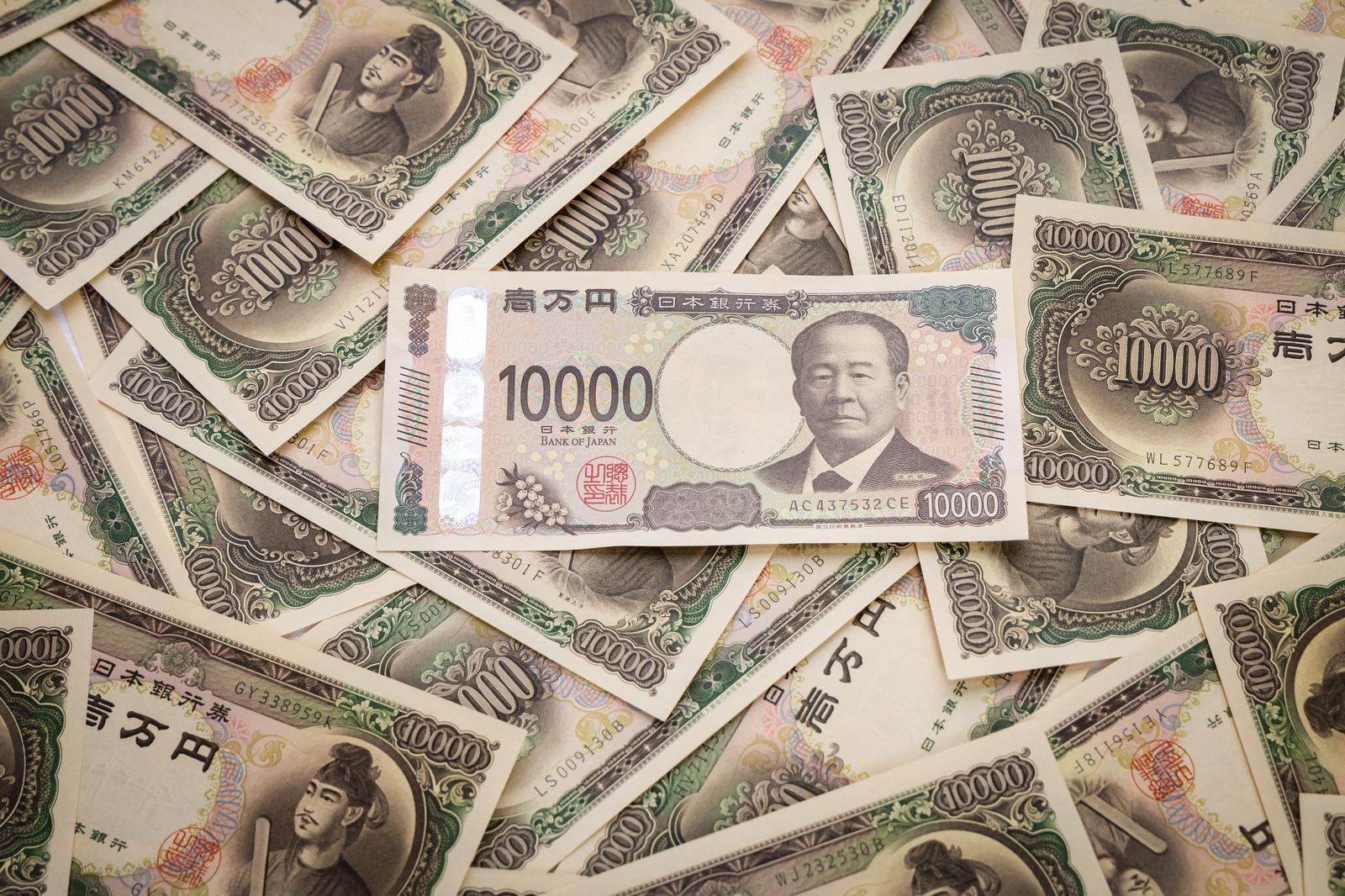 New 10,000 yen banknote of Eiichi Shibusawa surrounded by 10,000 yen banknotes with the portrait of Prince Shotoku in Japan