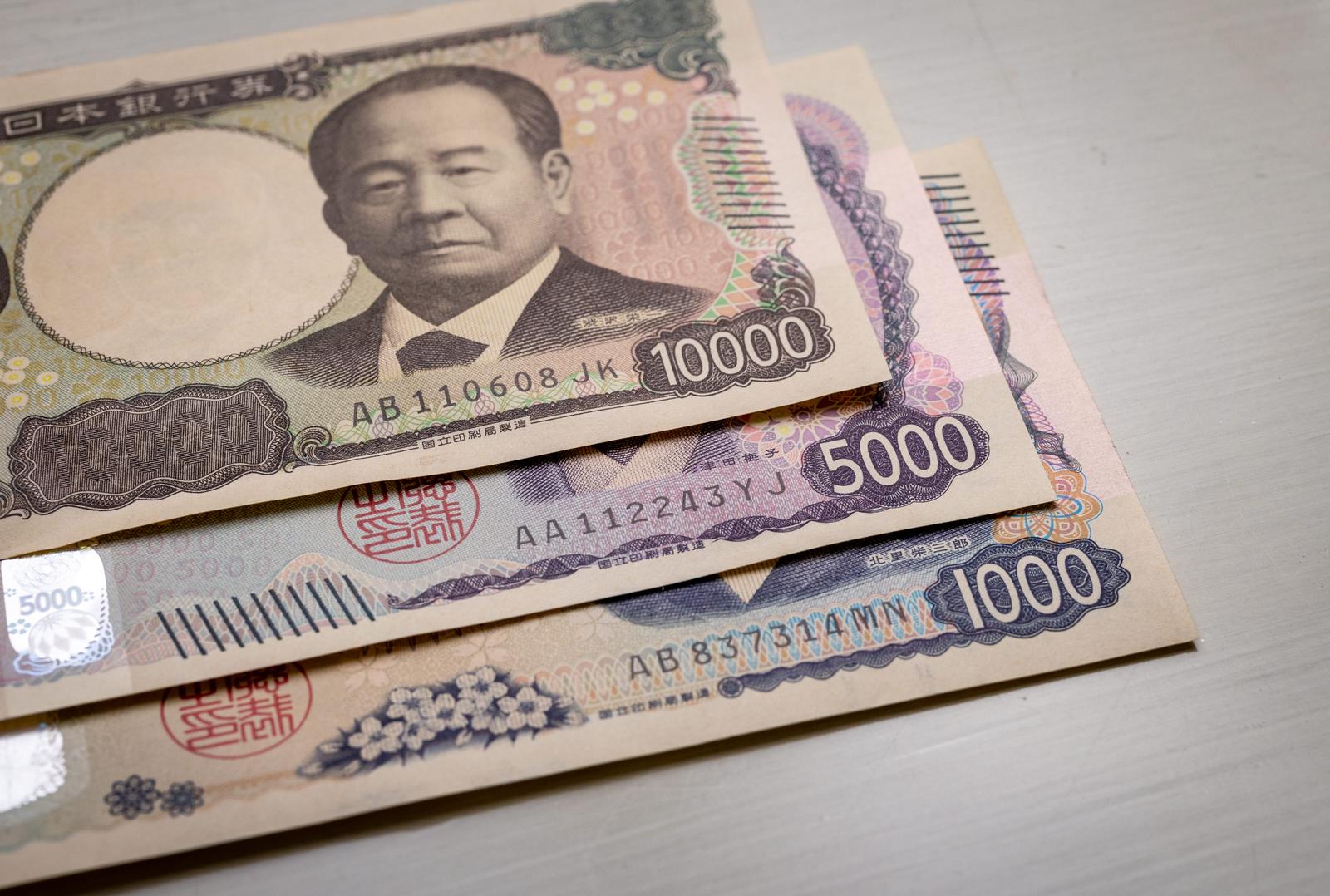 日本の新紙幣10000円、5000円、1000円を重ねて並べた現金の写真