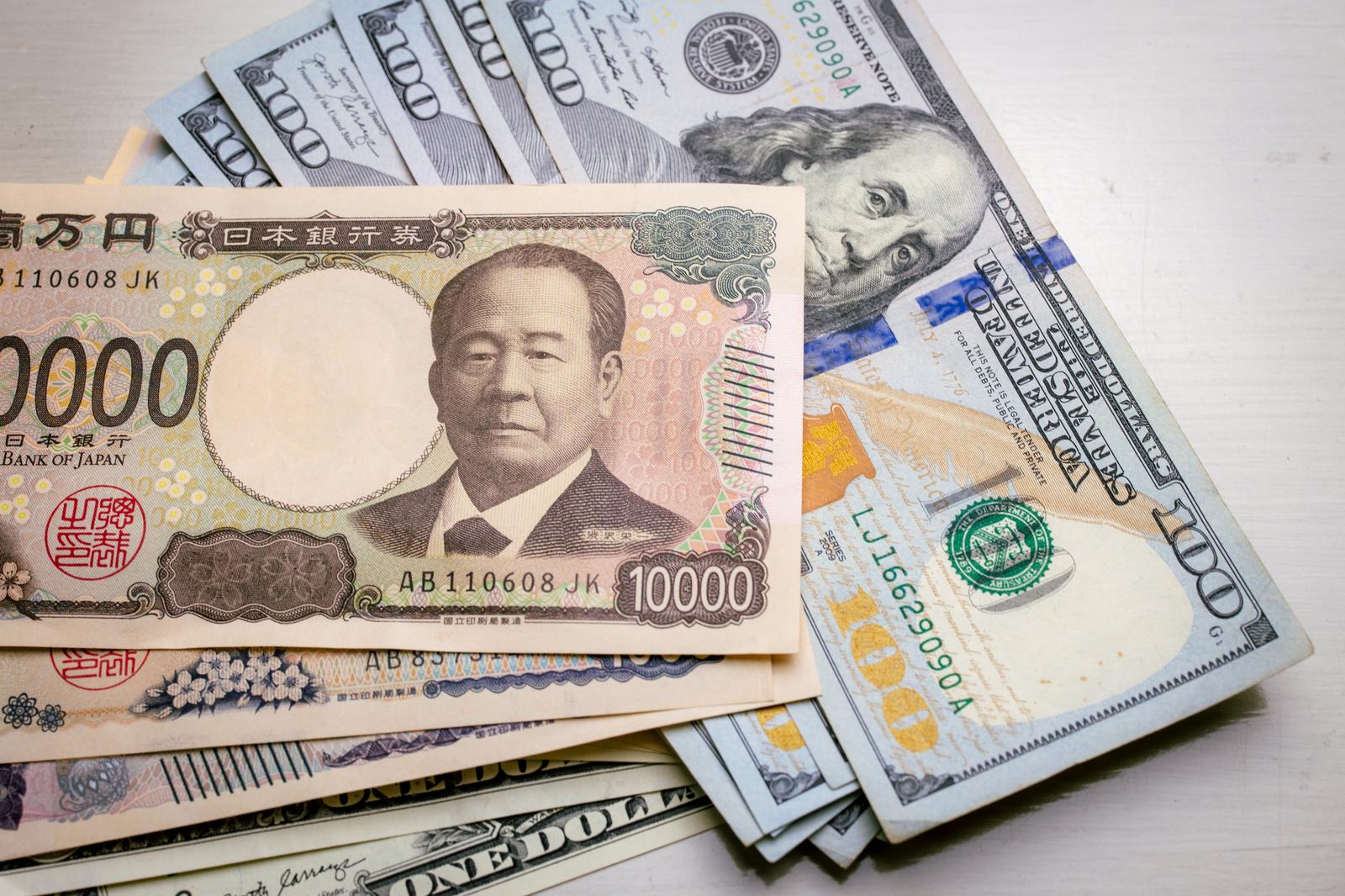 一万円札と百ドル札をテーブルに並べた俯瞰写真
