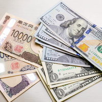 日米の紙幣が重なり合う現金両替と為替相場の写真