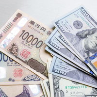 日本円の新紙幣1000円と10000円の上に米ドル紙幣が並ぶの写真