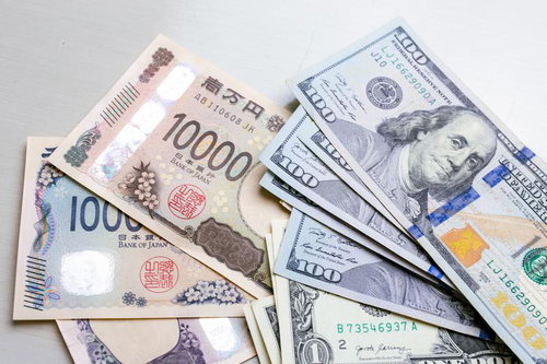 日本円の新紙幣1000円と10000円の上に米ドル紙幣が並ぶ