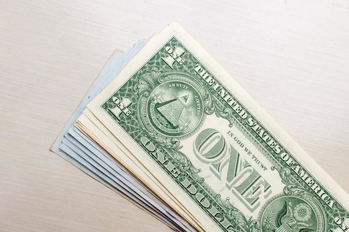 積み重なった1ドル紙幣に描かれたピラミッドとフリーメーソンのシンボル