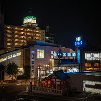 夜の椎名町駅前に佇む長崎神社の赤い鳥居とネオン街の写真