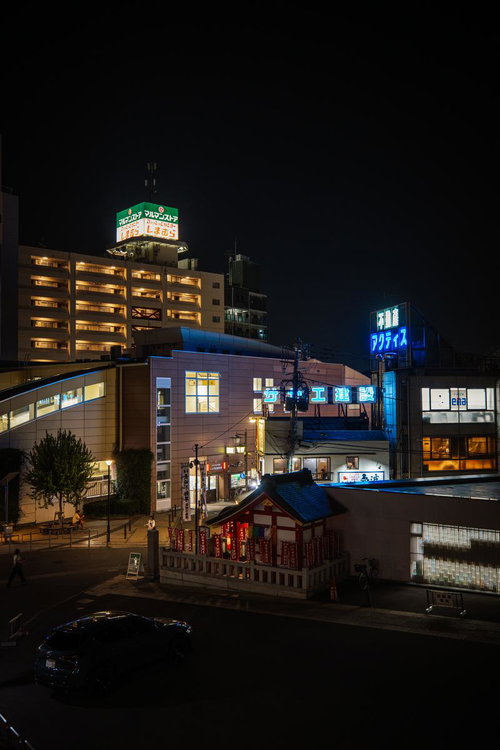 夜の椎名町駅前に佇む長崎神社の赤い鳥居とネオン街