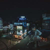 椎名橋から俯瞰した椎名町駅前の青いネオン街と夜の商店街の写真