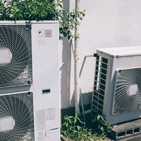 壁に設置された複数の室外機と配管工事の写真