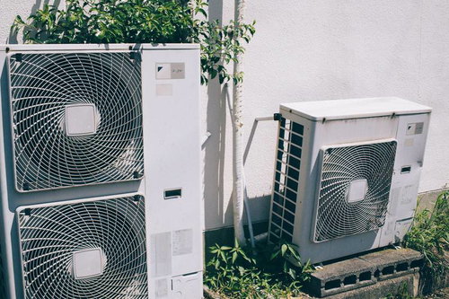 壁に設置された複数の室外機と配管工事